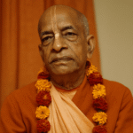 Portrait of A. C. Bhaktivedanta Swami Prabhupada in saffron robes with flower garland